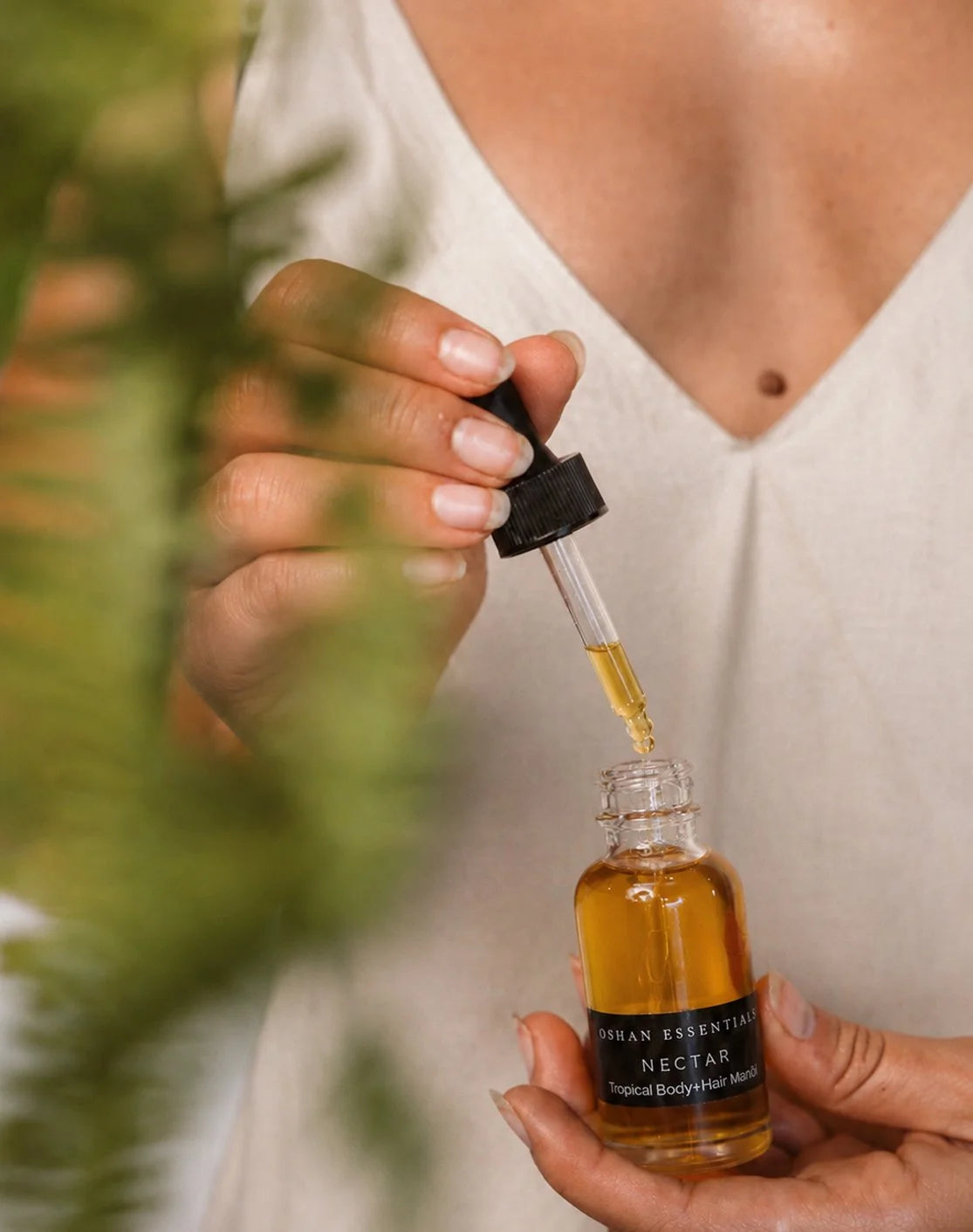 A woman draws NECTAR Manoʻi into the dropper