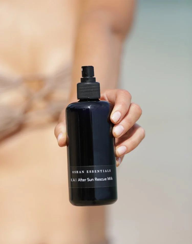Model at the shore holding the OSHAN KAI After Sun Rescue Milk bottle.