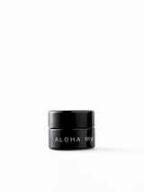 OSHAN ALOHA Lip Vitality Balm in its small black jar on a white background.