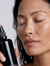 Model misting OSHAN ʻAWAPUHI Balancing Toner over her face, eyes closed.