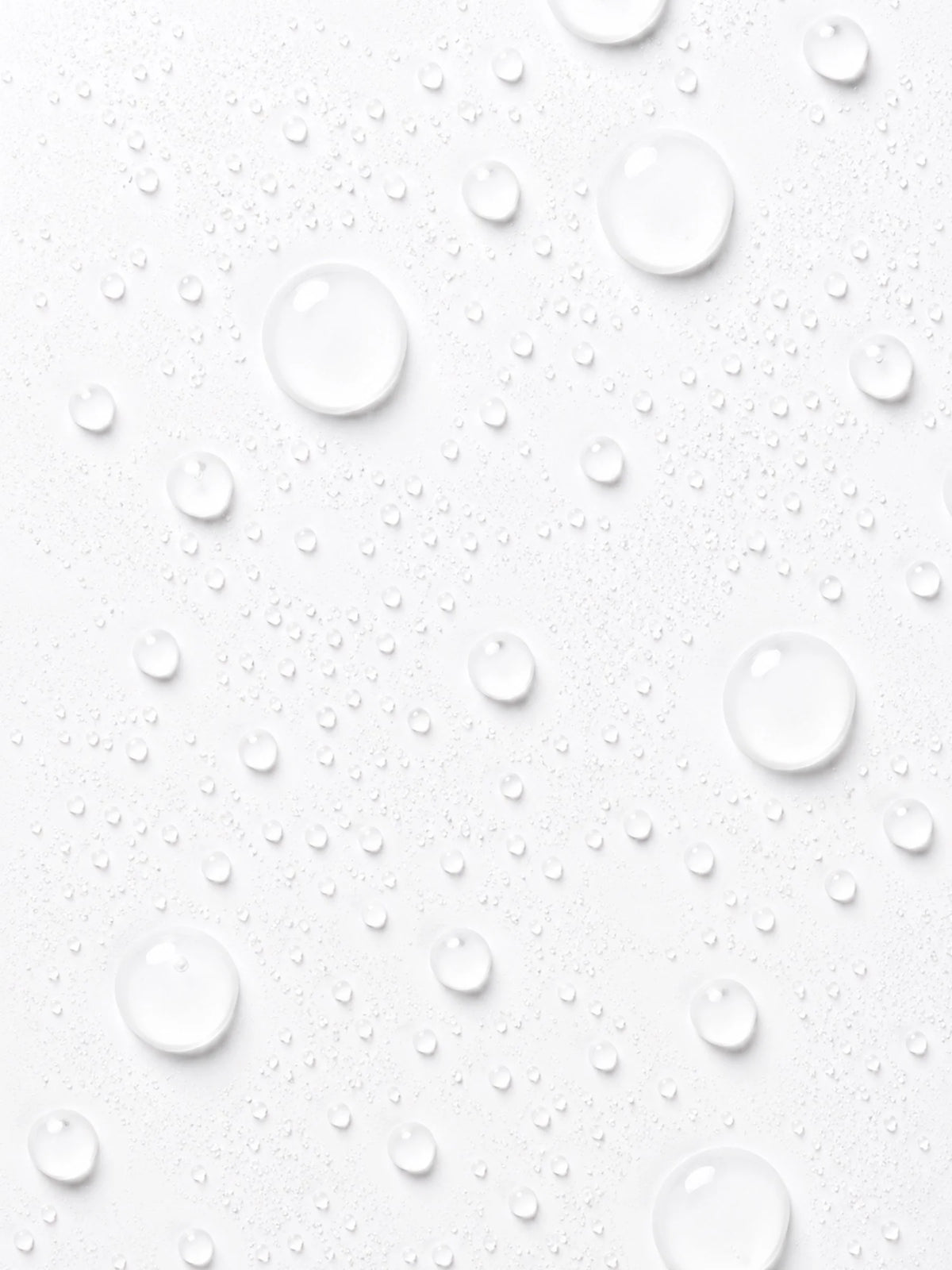 Clear droplets of OSHAN ʻAWAPUHI Balancing Toner across a white surface.