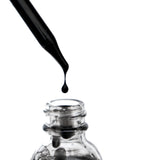 Black ʻELE face wash from the OSHAN BASIC Set pouring into a glass bottle.