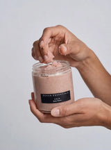 Hands scooping OSHAN CALM ʻĀKALA Body Polish from the open jar.