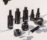 OSHAN Full Facial Ritual Set bottles and jars arranged with the black mixing bowl and spatula.