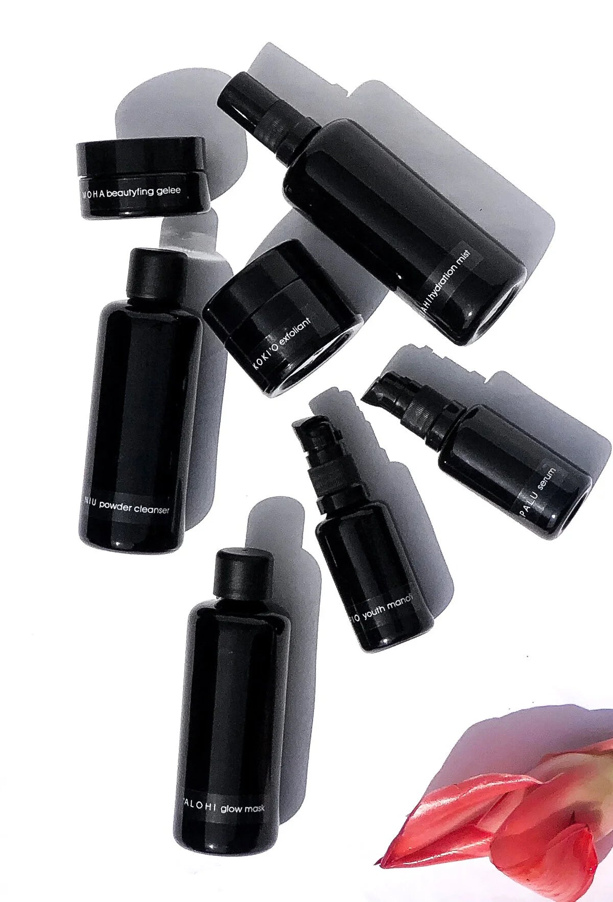 Flat lay of the full OSHAN Full Facial Ritual Set line up in black glass.
