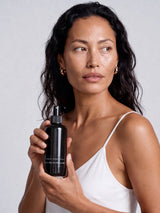 Model holding a bottle of OSHAN KAI After Sun Rescue Milk.