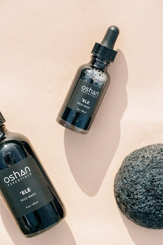 OSHAN KONJAC Sponge beside the ʻELE Clarifying Face Wash bottles on a blush surface.