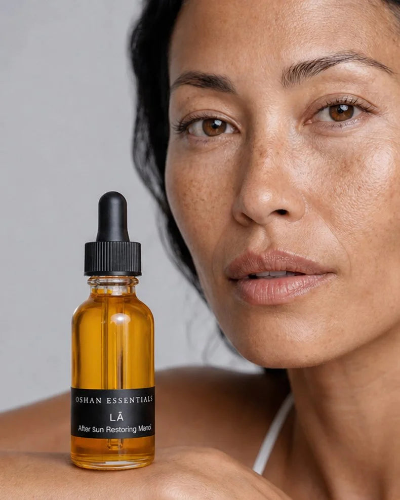 Model holding the OSHAN LĀ Soothing After Sun Manoʻi bottle at her shoulder.