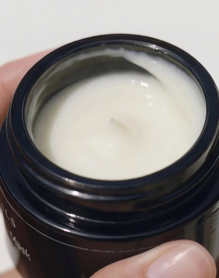 Hand holding the open jar of OSHAN MĀLIE Cellular Hydration Mask.