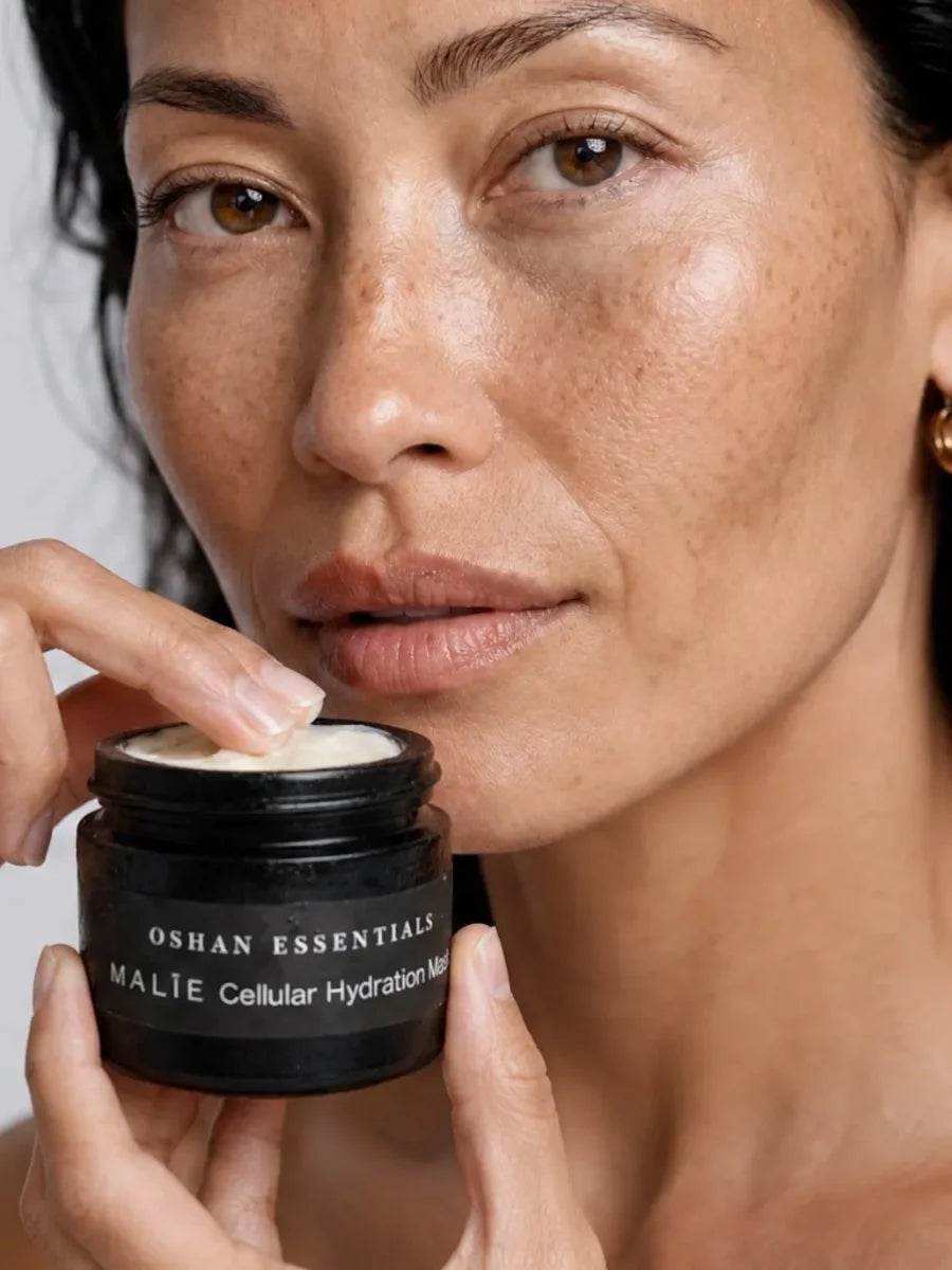 Model taking OSHAN MĀLIE Cellular Hydration Mask from the jar with her fingertip.