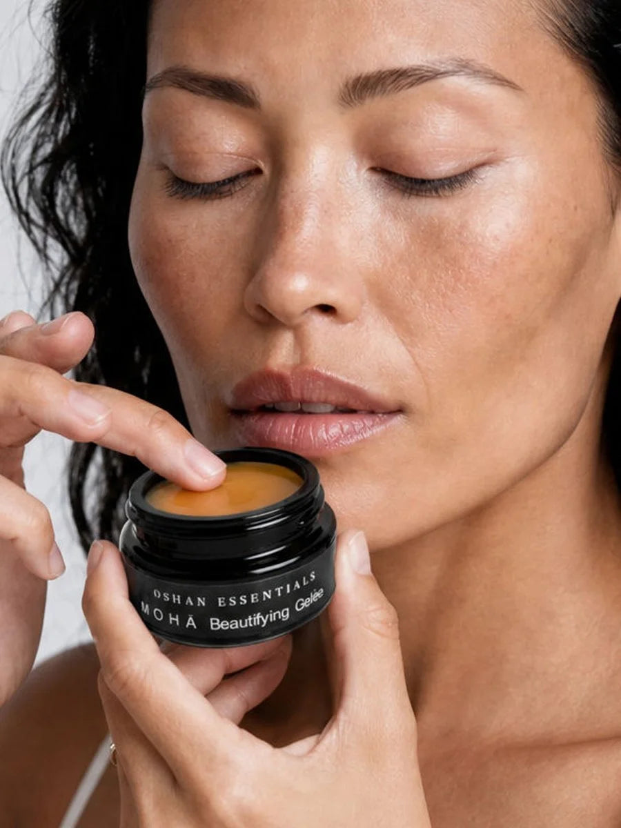 Model holding an open jar of OSHAN MOHĀ Beautifying Concrete Gelée near her face.