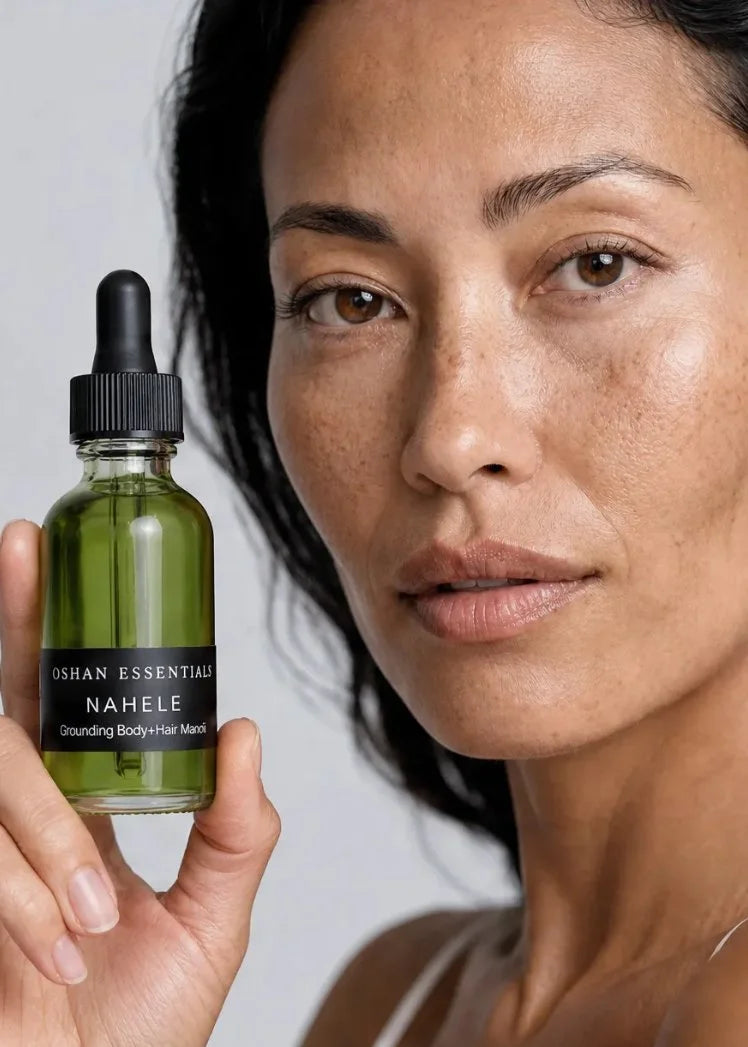 Model holding the OSHAN NAHELE Grounding Body and Hair Manoʻi bottle beside her face.