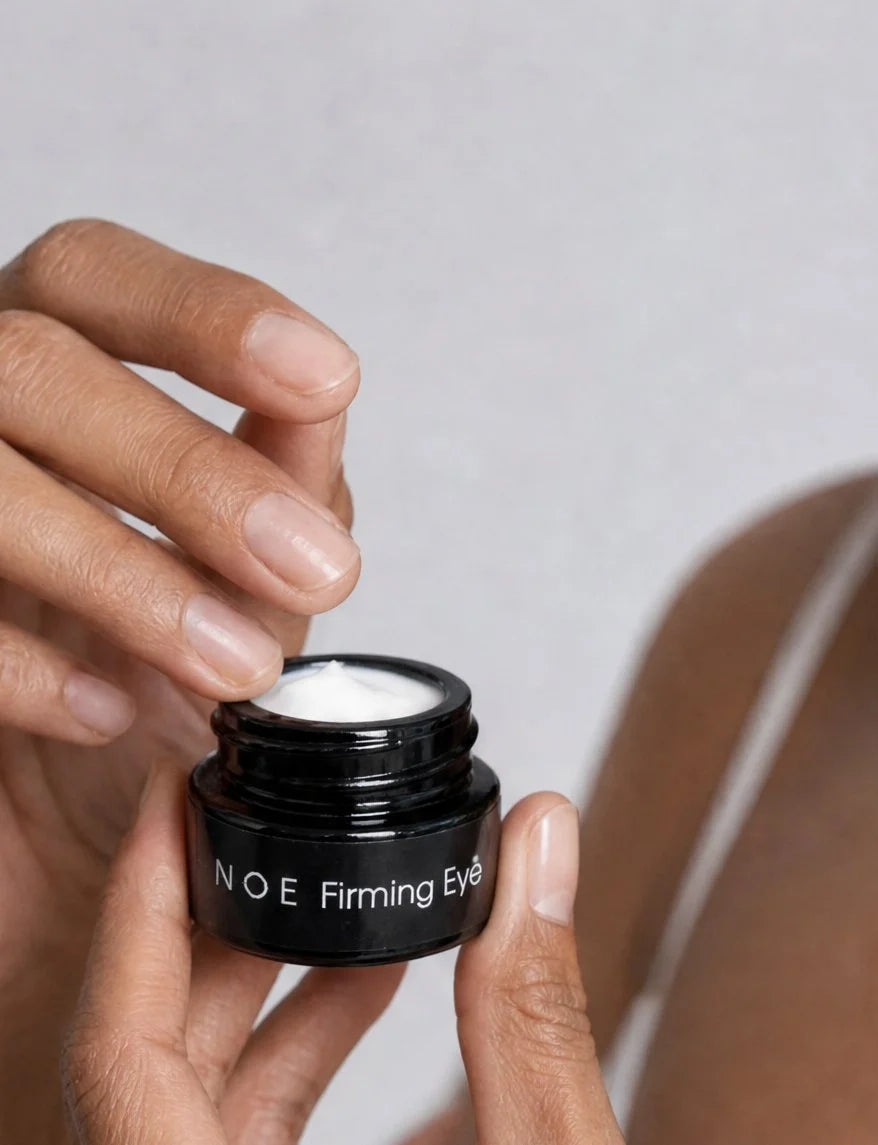 Hands opening a jar of OSHAN NOE Firming Eye Cream.