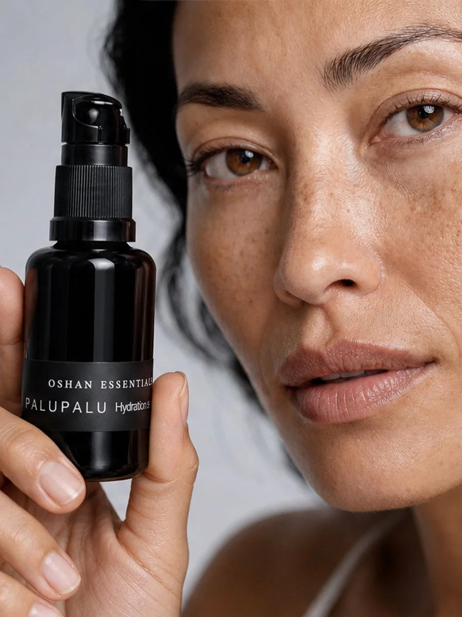 Model holding the OSHAN PALUPALU Hydration Serum bottle beside her face.