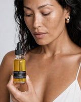 Model holding the OSHAN WAI Invigorating Hair and Body Manoʻi bottle at her shoulder.