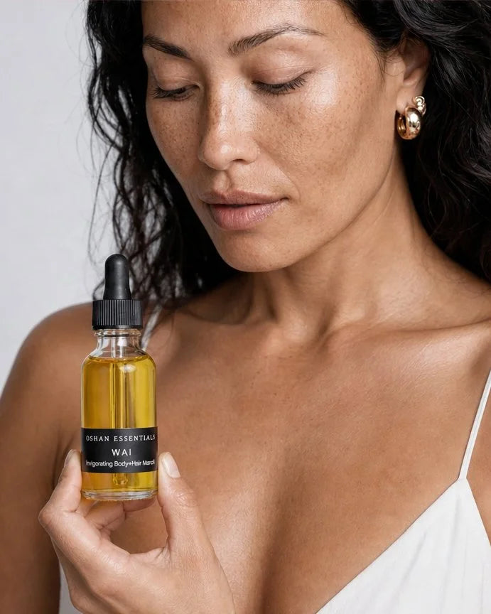 Model holding the OSHAN WAI Invigorating Hair and Body Manoʻi bottle at her shoulder.